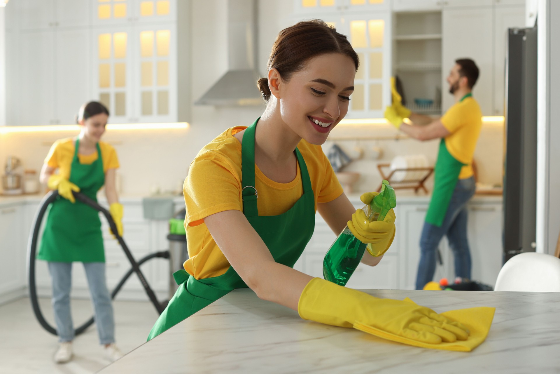 Team of professional janitors working in kitchen